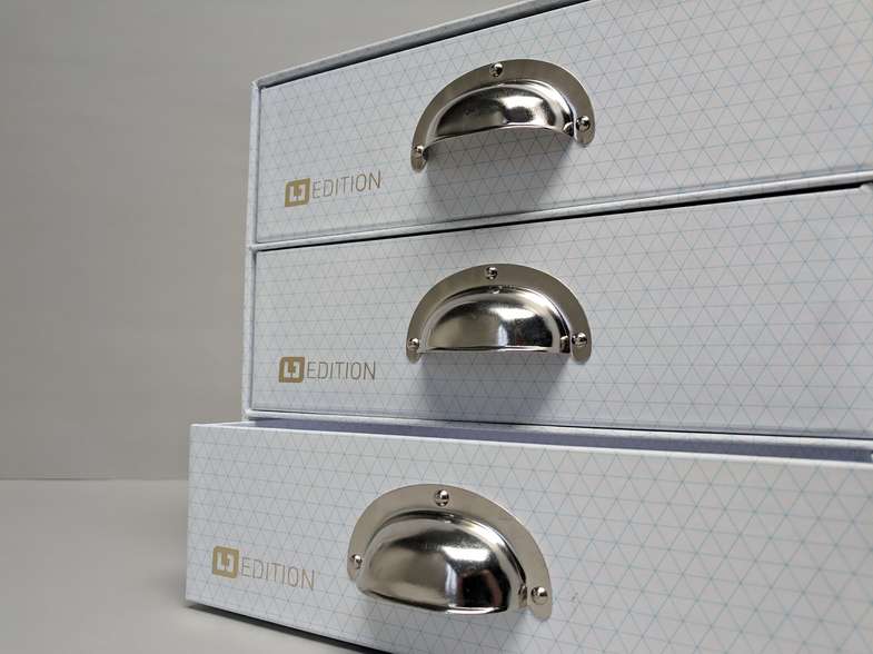 Kartonage mit drei Schubladen, untere leicht geöffnet - Stehsammler Schuber