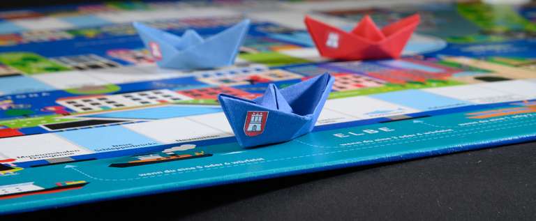 Brettspiele produzieren lassen Faltböötchen auf Brettspiel, Nahaufnahme - Brettspiele produzieren lassen